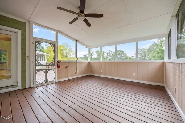 a view of empty room with wooden floor and fan