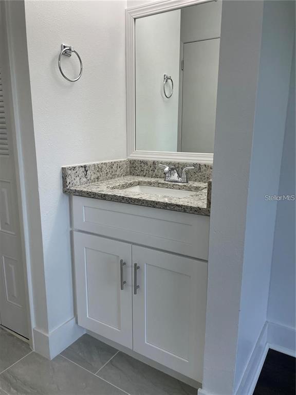 199 Afton Square, Unit 309 Altamonte Springs, FL 32714 - Photo 15 of 17 a bathroom with a granite countertop sink and a mirror