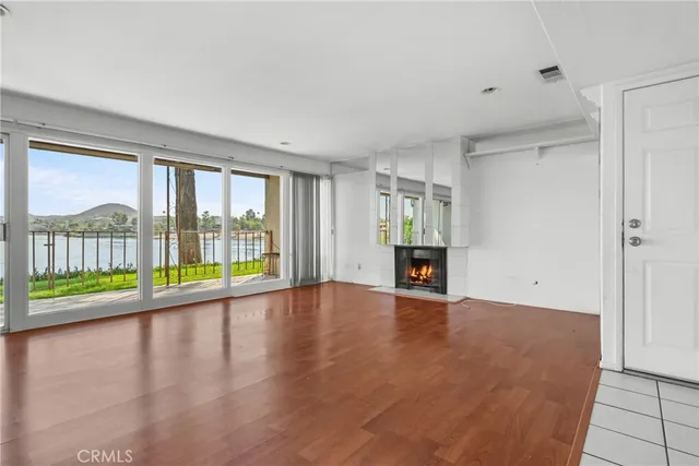 a view of empty room with wooden floor and fireplace