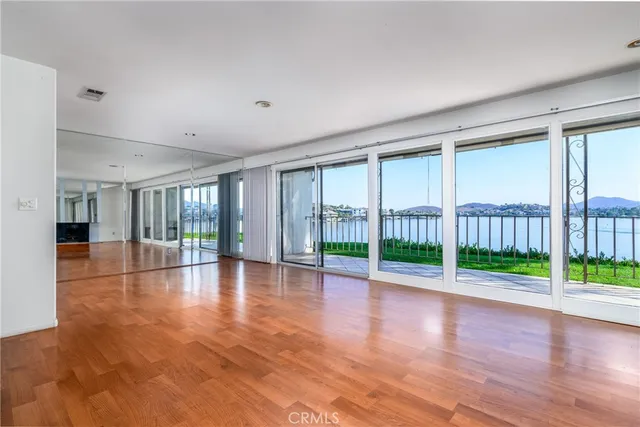 a view of empty room with wooden floor and floor to ceiling window