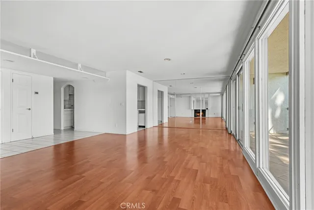 a view of a big room with wooden floor and a window