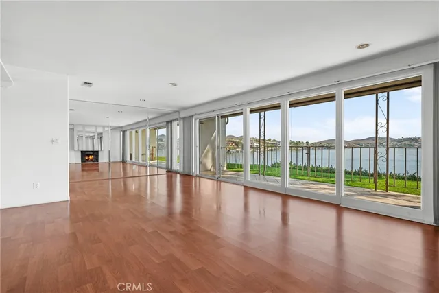 a view of empty room with wooden floor and floor to ceiling window