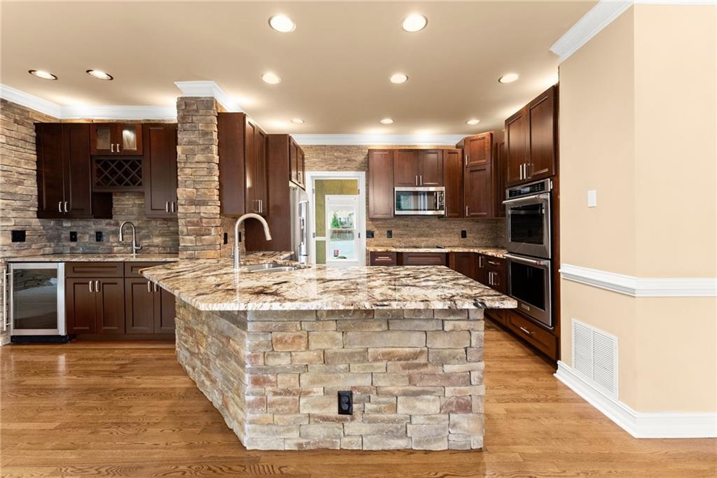 4863 Rosemoore Court Suwanee, GA 30024 - Photo 17 of 74 a kitchen with kitchen island stainless steel appliances a sink stove and cabinets