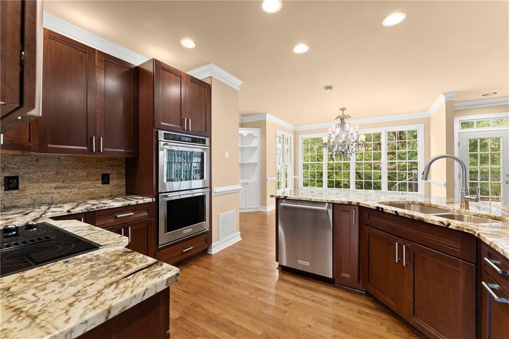 4863 Rosemoore Court Suwanee, GA 30024 - Photo 19 of 74 a kitchen with stainless steel appliances granite countertop a stove a sink and a microwave
