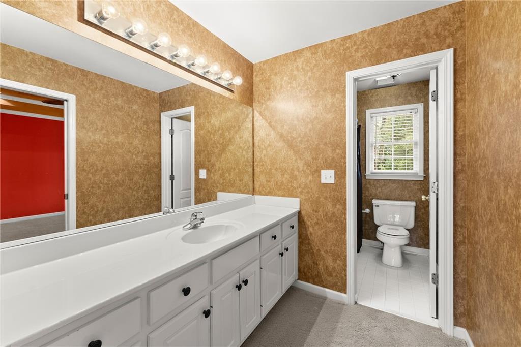 4863 Rosemoore Court Suwanee, GA 30024 - Photo 26 of 74 a bathroom with a double vanity sink and a toilet