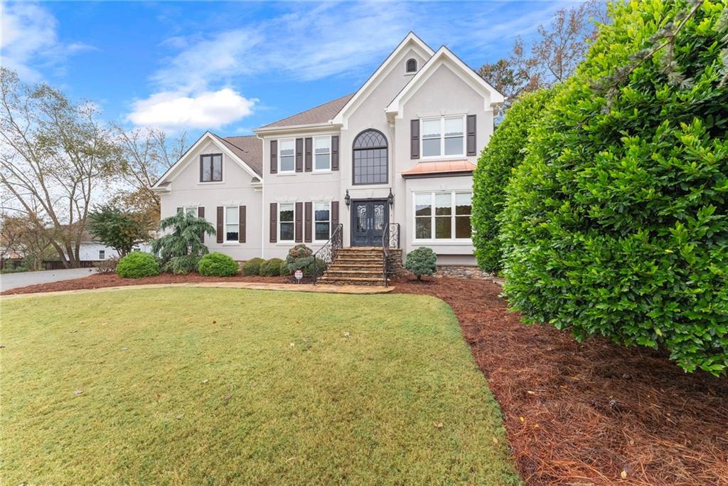 4863 Rosemoore Court Suwanee, GA 30024 - Photo 46 of 74 a front view of a house with yard and green space