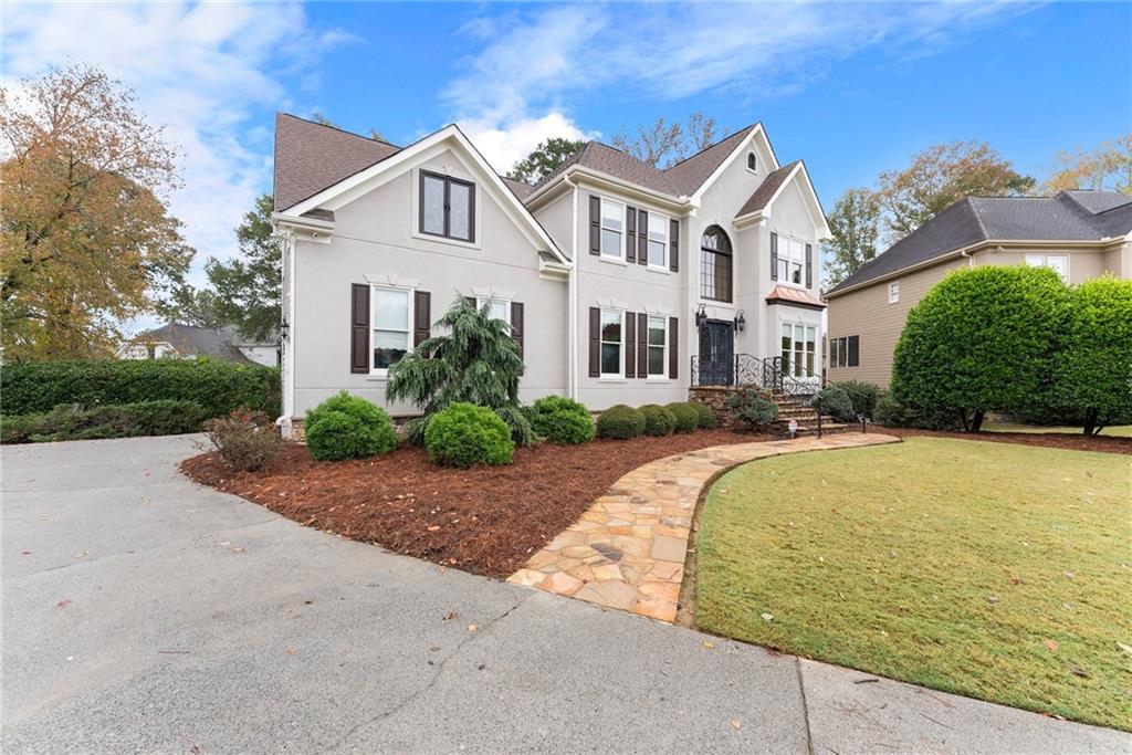 4863 Rosemoore Court Suwanee, GA 30024 - Photo 47 of 74 a front view of a house with a yard and garage