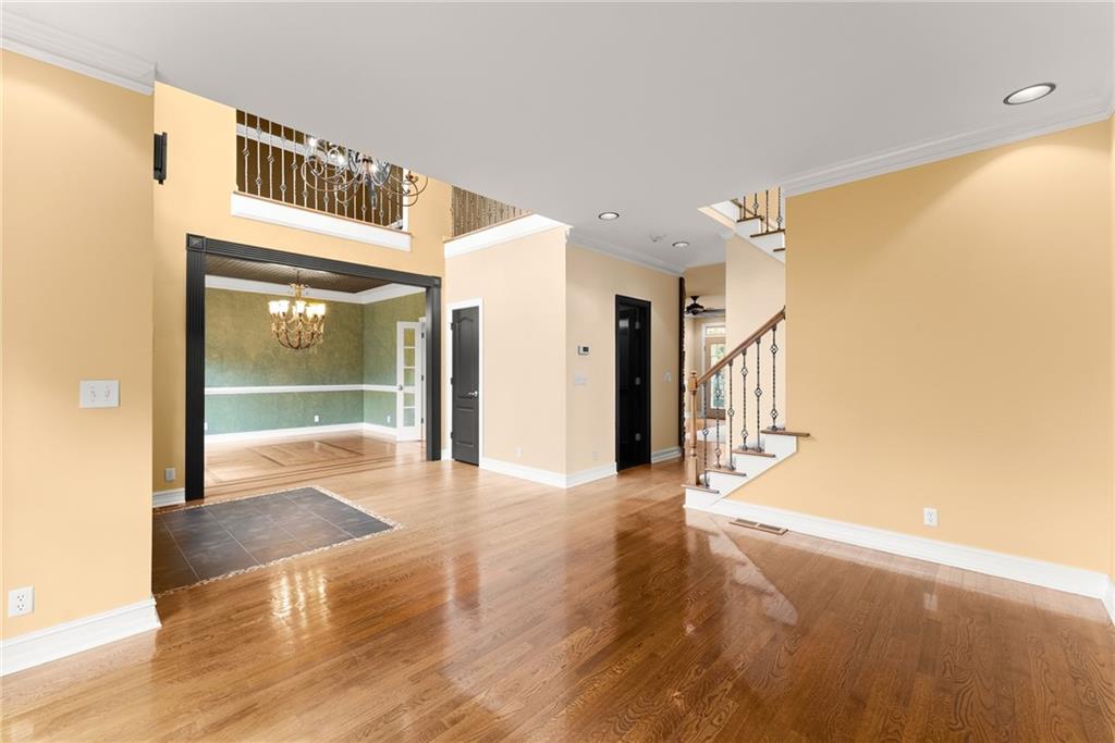 4863 Rosemoore Court Suwanee, GA 30024 - Photo 8 of 74 a view of a hallway with wooden floor and door
