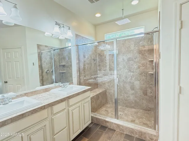 a bathroom with a shower sink and mirror
