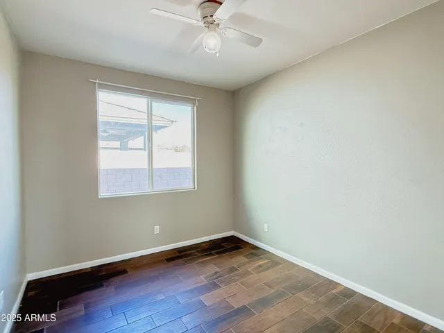 an empty room with a window and wooden floor