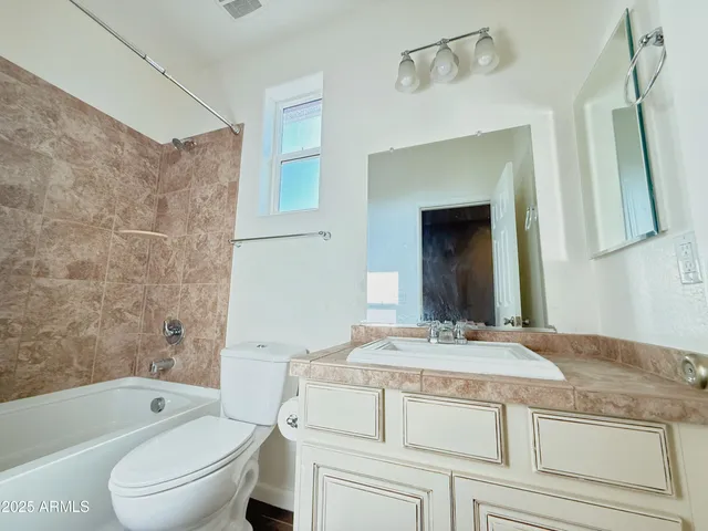 a bathroom with a granite countertop sink a toilet and bathtub