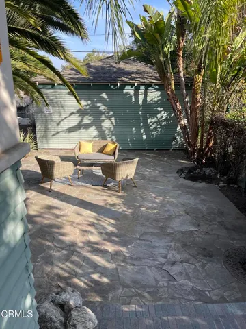 a view of backyard with a table and chairs under an umbrella