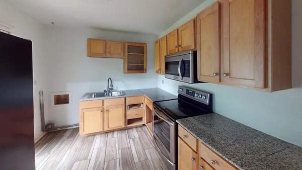 a kitchen with stainless steel appliances granite countertop a sink stove and microwave