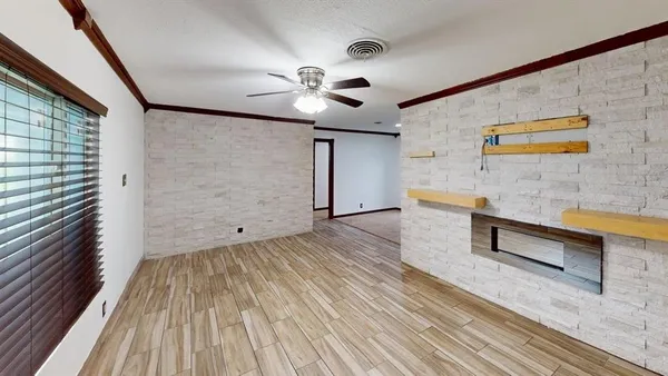 a view of workspace with wooden floor and fan