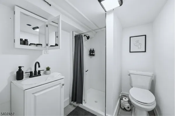 a bathroom with a toilet sink vanity and mirror