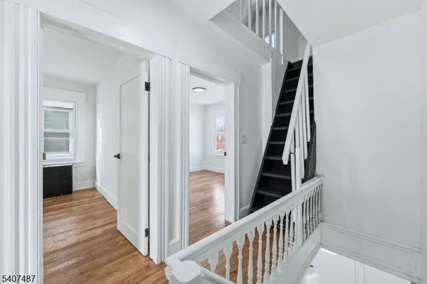a view of a hallway with wooden floor and entryway