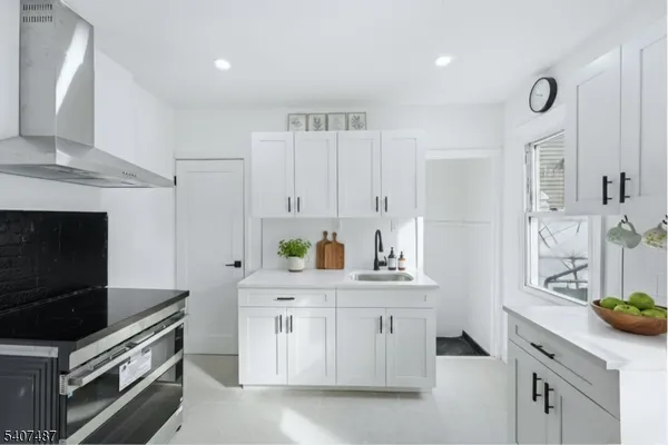 a kitchen with stainless steel appliances a stove a sink a refrigerator and cabinets