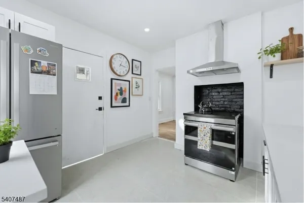 a kitchen with stainless steel appliances a stove a refrigerator and a potted plant