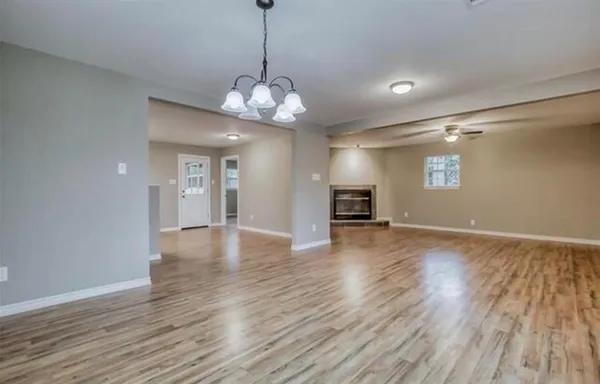 a view of a big room with wooden floor and windows