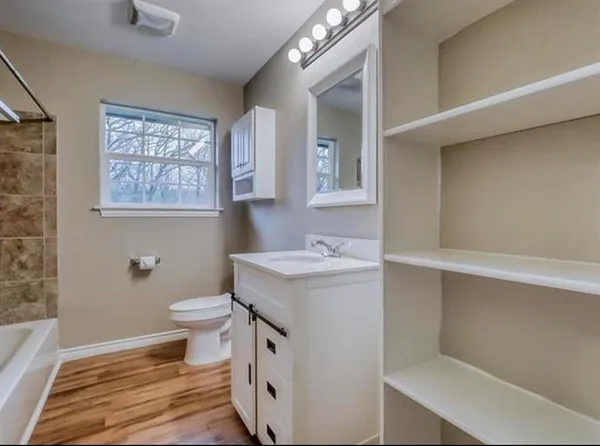 a bathroom with a sink toilet and window