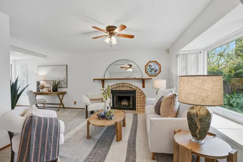 a living room with furniture a chandelier and a fireplace