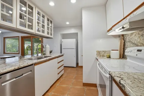 a kitchen with stainless steel appliances granite countertop a sink and a stove