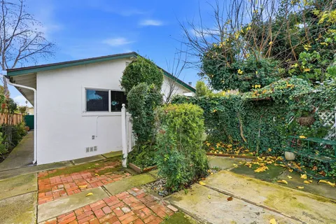 a backyard of a house with flower plants