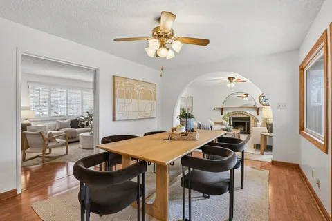 a view of a dining room with furniture a chandelier and wooden floor