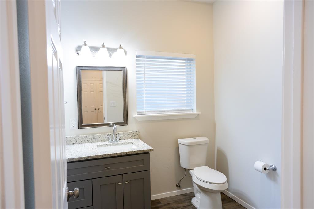4522 Reiger Avenue Dallas, TX 75246 - Photo 26 of 37 Bathroom with vanity, toilet, and hardwood / wood-style floors