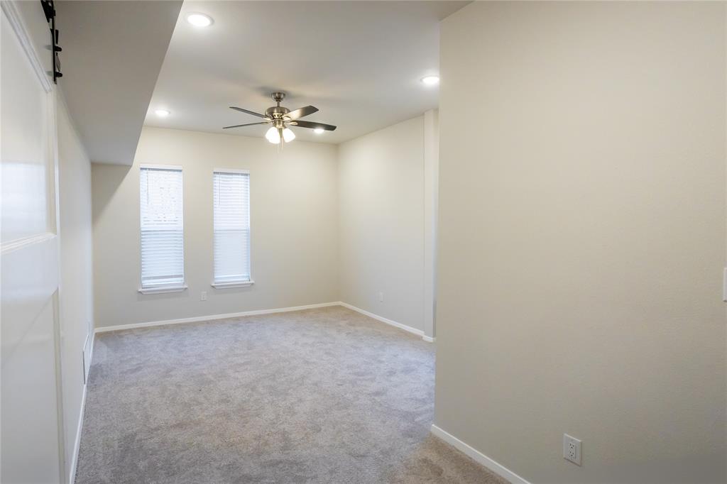4522 Reiger Avenue Dallas, TX 75246 - Photo 27 of 37 Carpeted empty room with ceiling fan