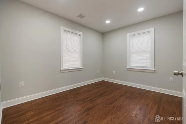 a view of a big room with wooden floor and windows