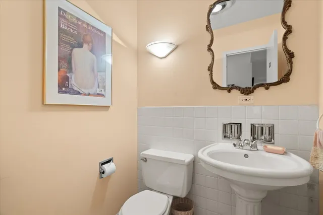 a bathroom with a toilet a sink and mirror