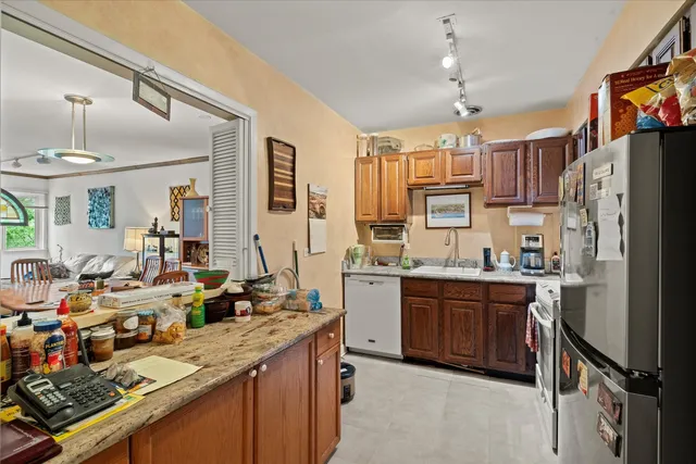 a kitchen with granite countertop a sink stove and refrigerator