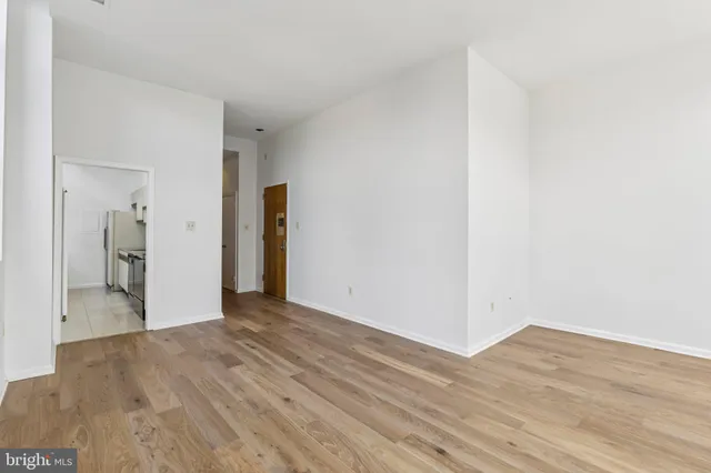 a view of empty room with wooden floor