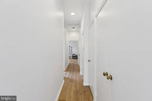 a view of a hallway with wooden floor and closet