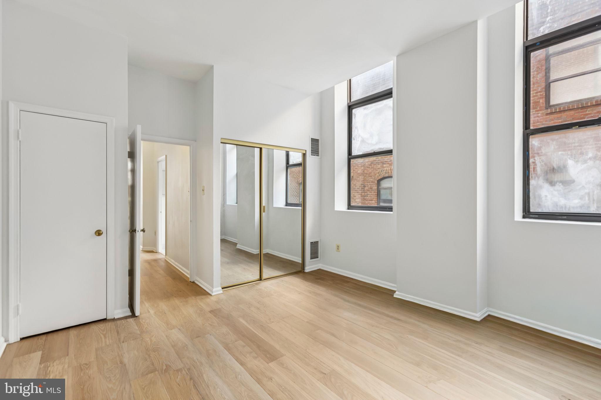 3299 K Street Northwest, Unit 304 Washington, DC 20007 - Photo 27 of 31 an empty room with wooden floor and windows