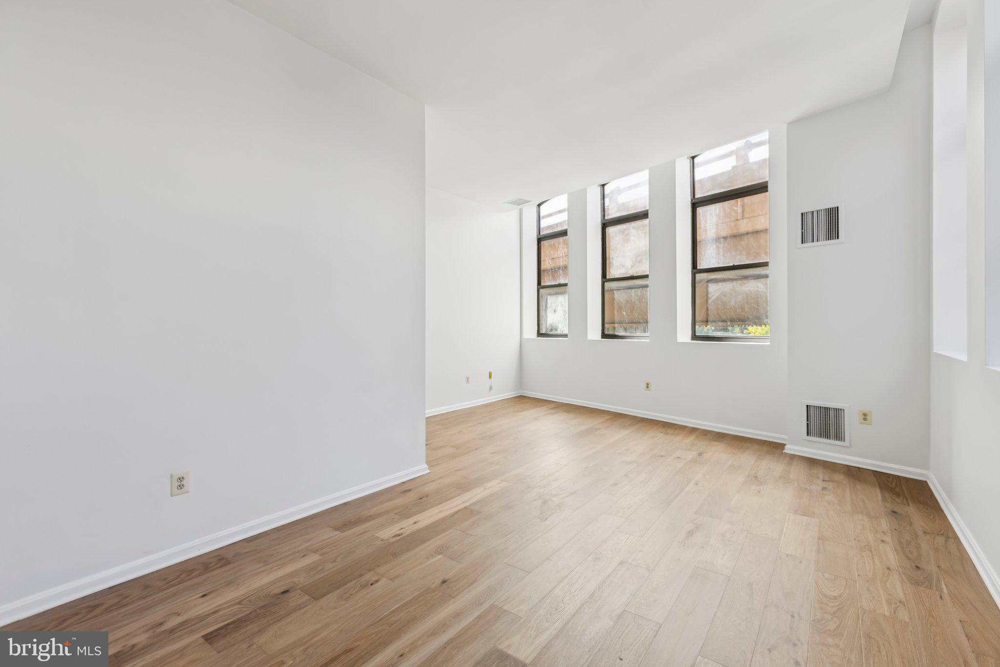 3299 K Street Northwest, Unit 304 Washington, DC 20007 - Photo 6 of 31 an empty room with wooden floor and windows
