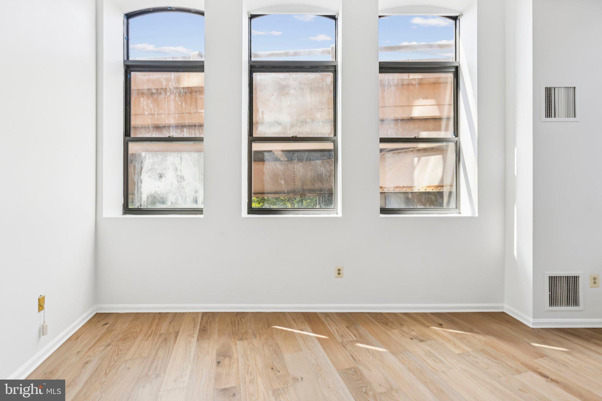 3299 K Street Northwest, Unit 304 Washington, DC 20007 - Photo 8 of 31 an empty room with wooden floor and windows