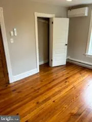 an empty room with wooden floor and closet