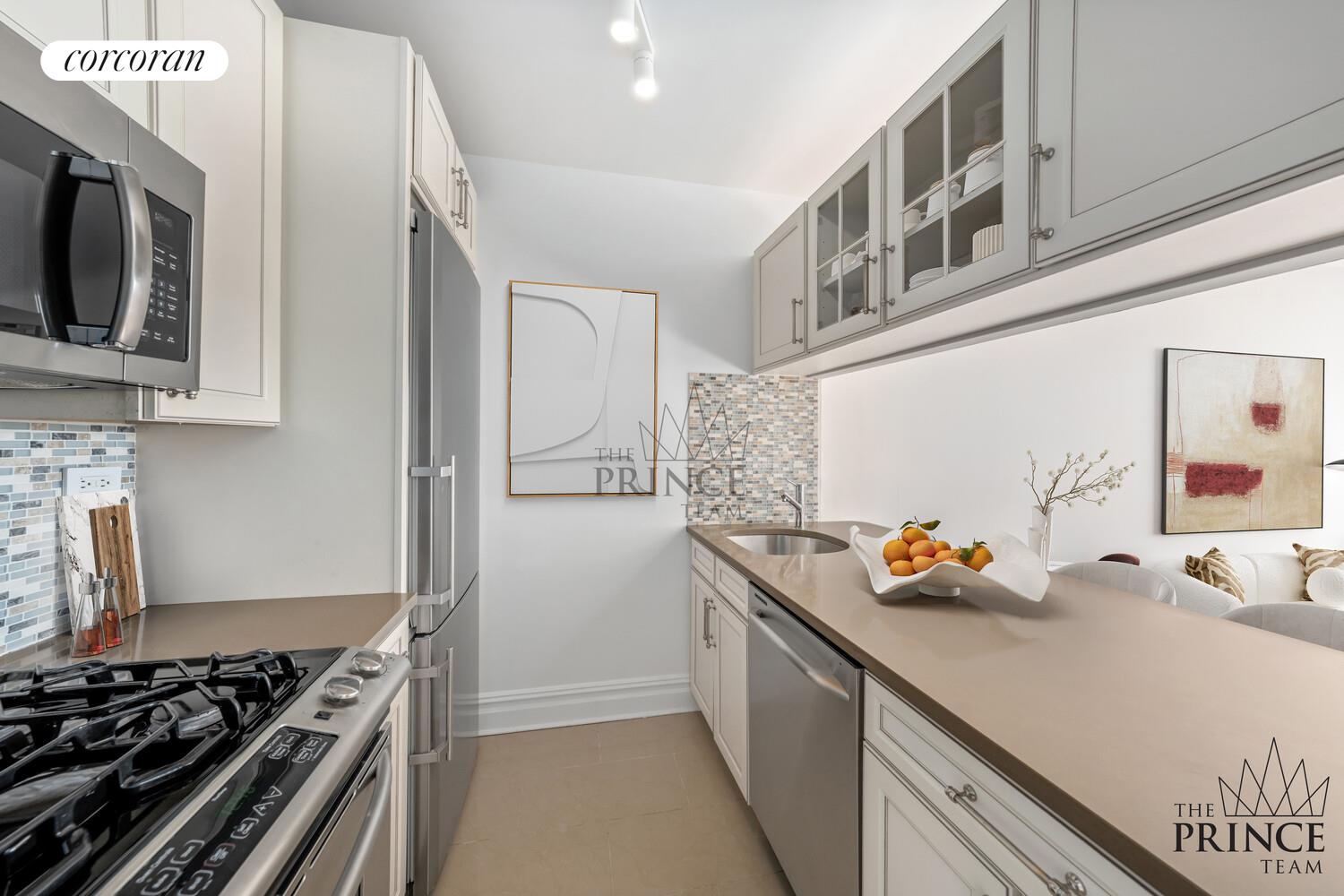 380 Rector Place, Unit 10F Manhattan, NY 10280 - Photo 3 of 14 a kitchen with stainless steel appliances a stove a microwave and cabinets