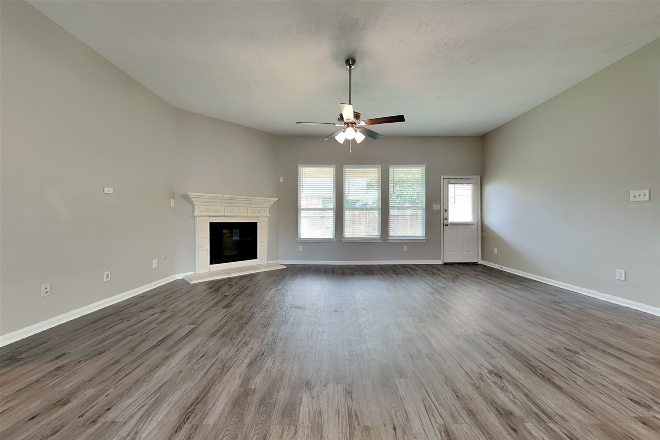 30710 Basil Trace Drive Spring, TX 77386 - Photo 3 of 18 an empty room with wooden floor fireplace and windows