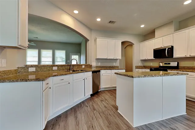 a large kitchen with cabinets a sink and appliances