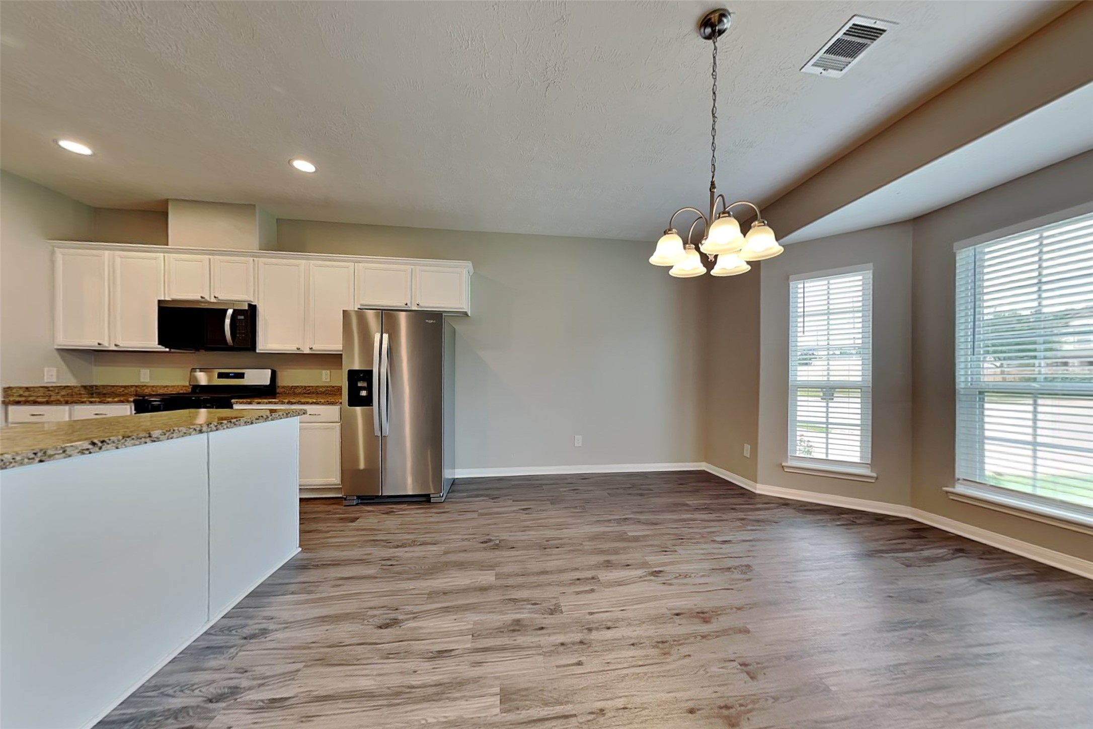 30710 Basil Trace Drive Spring, TX 77386 - Photo 8 of 18 a kitchen with stainless steel appliances granite countertop a refrigerator a stove a sink dishwasher and a microwave oven on the wooden floor
