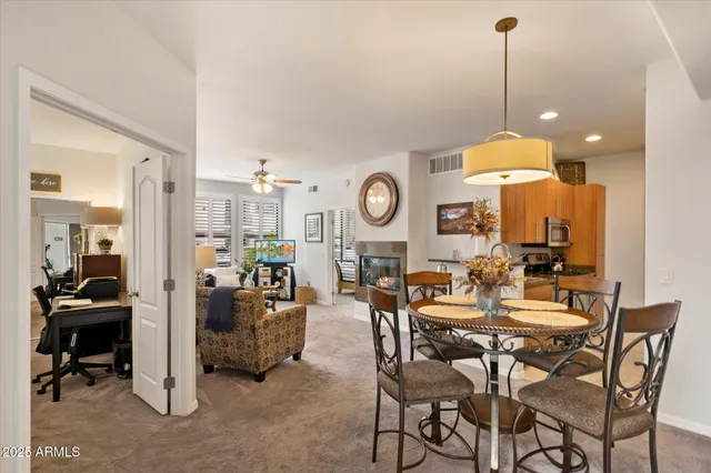 a view of a dining room and livingroom with furniture wooden floor a chandelier