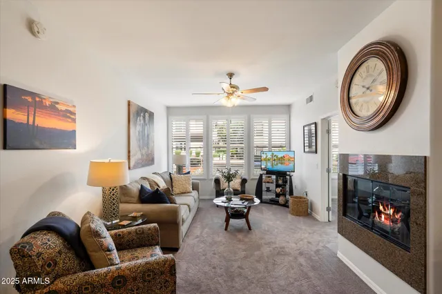 a living room with furniture a fireplace and a large window