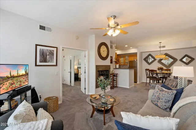 a living room with furniture a clock and a flat screen tv