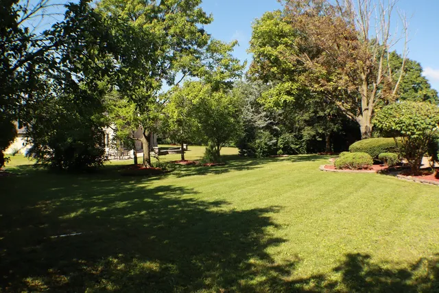 a view of swimming pool with a garden and trees
