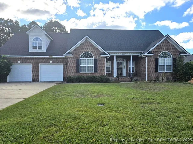 a front view of a house with a garden and yard