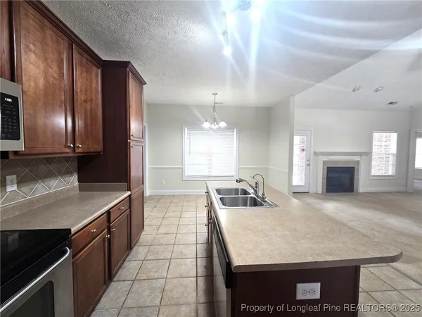 a kitchen with stainless steel appliances granite countertop a sink dishwasher stove refrigerator and cabinets