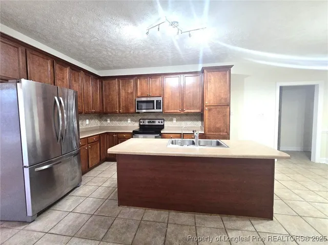 a kitchen with kitchen island granite countertop a stove cabinets and refrigerator